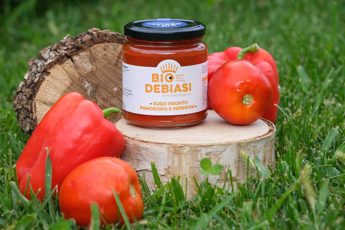 vasetto di sugo pronto pomodoro e peperoni biologico biodebiasi in vetro in ambientazione all'aperto