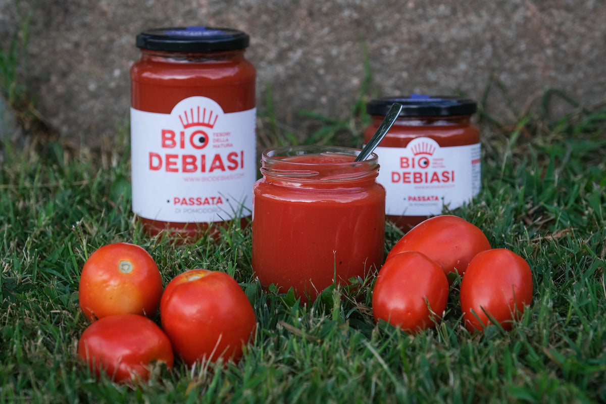 vasetto di passata di pomodoro biologico biodebiasi in vetro in ambientazione all'aperto 