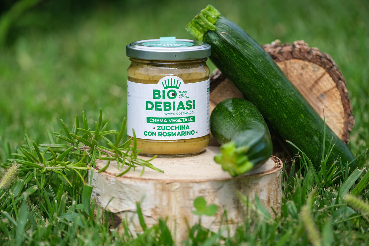 vasetto di crema vegetale di zucchina con rosmarino biologico  biodebiasi in vetro  in ambientazione all'aperto